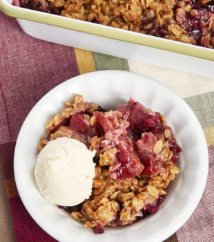 fruit crisp served in a white bowl with ice cream