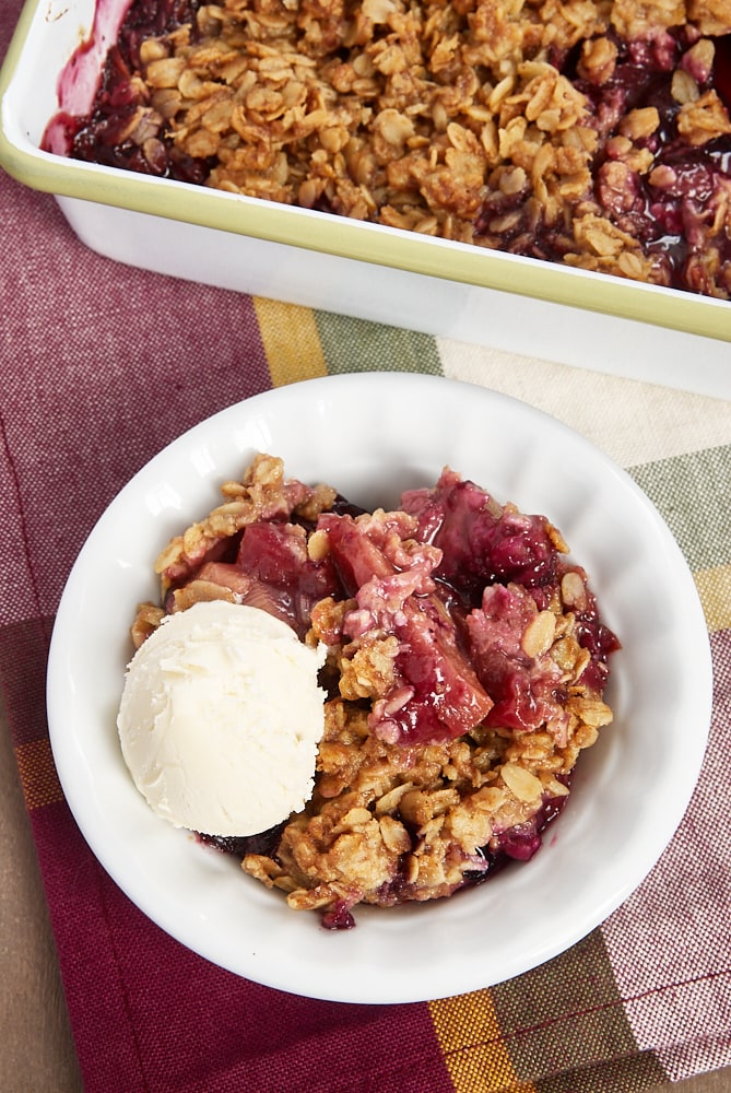 fruit crisp served in a white bowl with ice cream