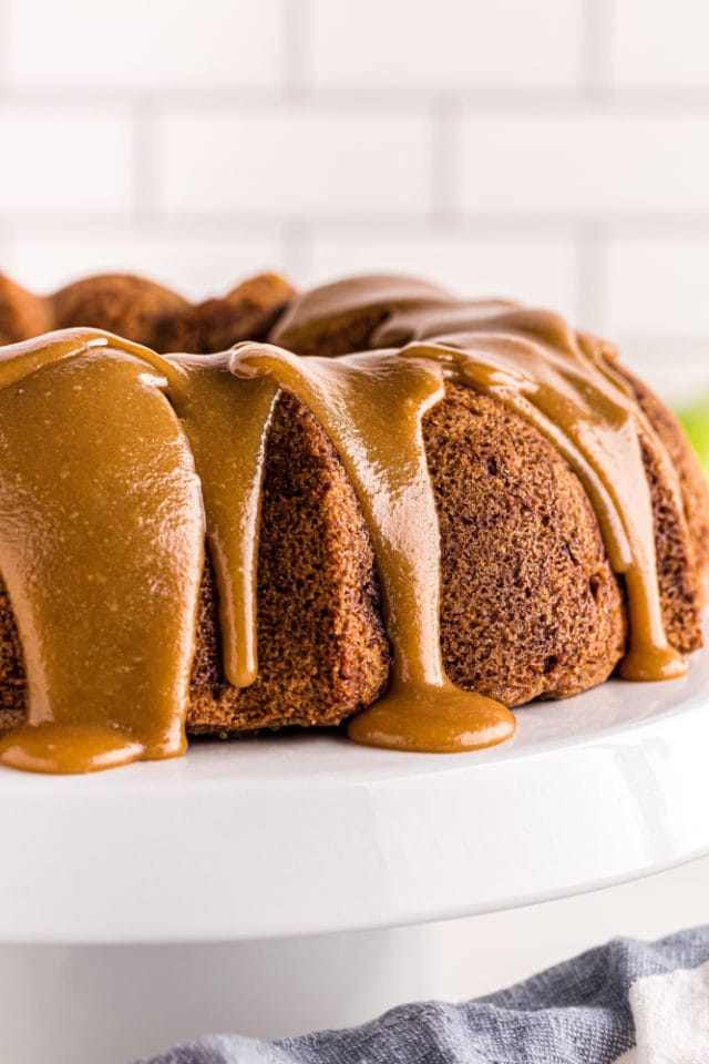 caramel-glazed Apple Spice Cake on a white cake stand