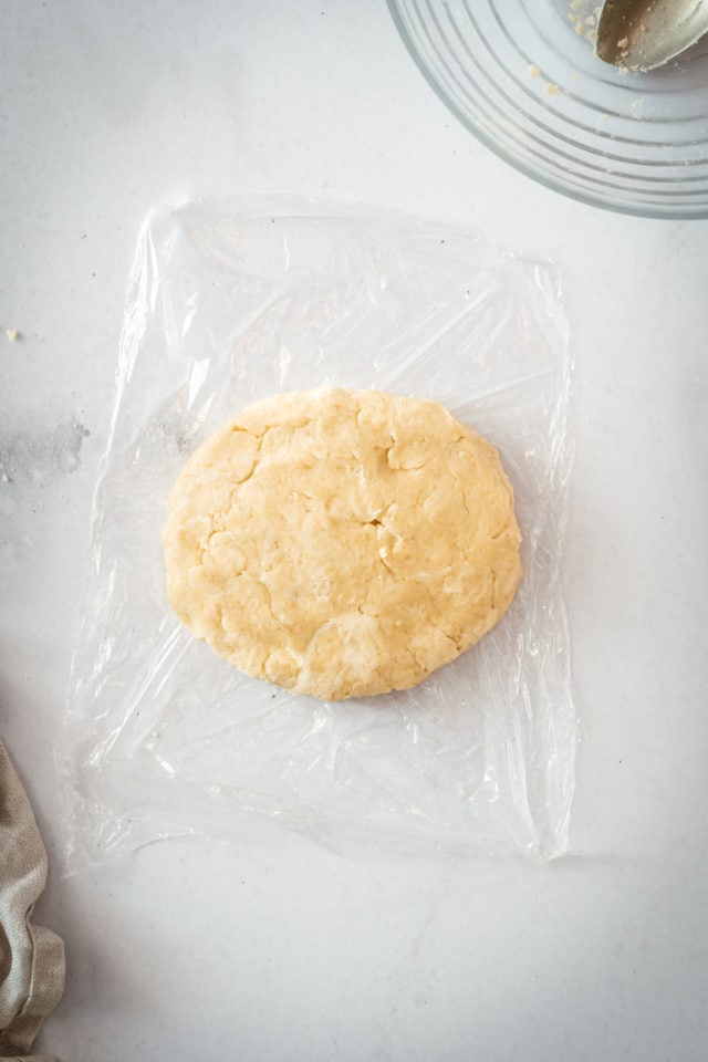 Overhead shot of pie dough wrapped in plastic