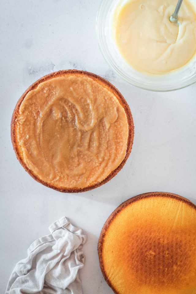 Overhead shot of caramel spread on one layer of Caramel Cake
