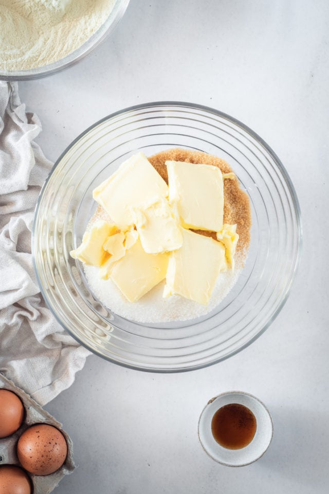 Overhead shot of butter and sugar in a glass bowl.