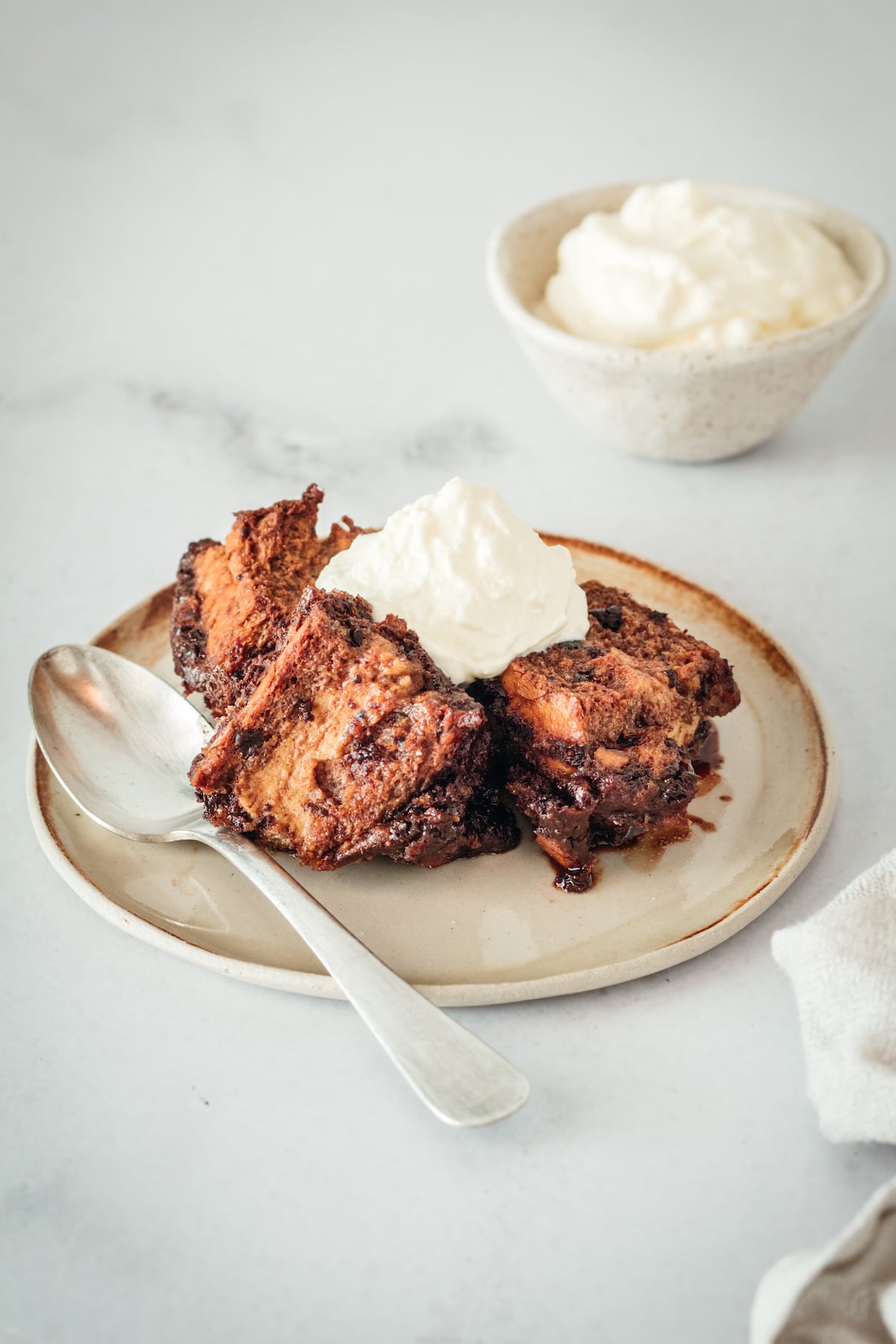 Chocolate Bread Pudding on plate, topped with whipped cream