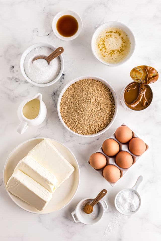 ingredients for Dulce de Leche Cheesecake Bars, including cream cheese, dulce de leche, graham cracker crumbs, and sugar