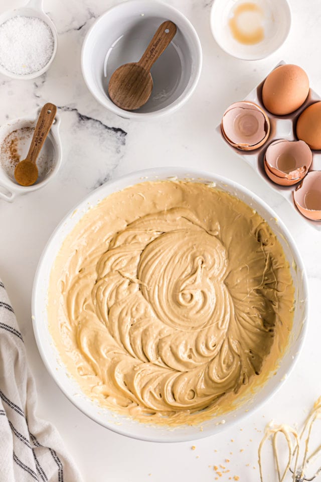 overhead view of dulce de leche cheesecake filling in a white mixing bowl