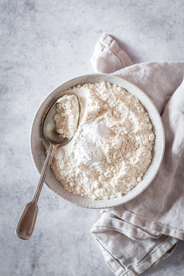 Overhead shot of dry cake ingredients in large bowl with spoon