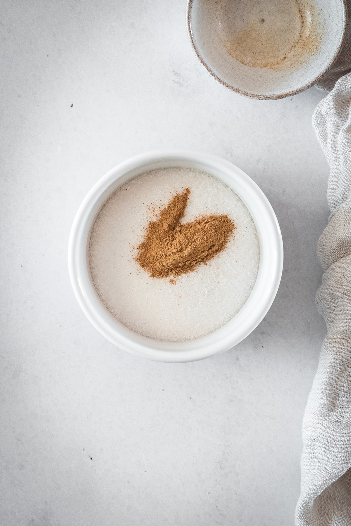 Overhead shot of sugar bowl with cinnamon, ready for mixing to create the cinnamon sugar topping