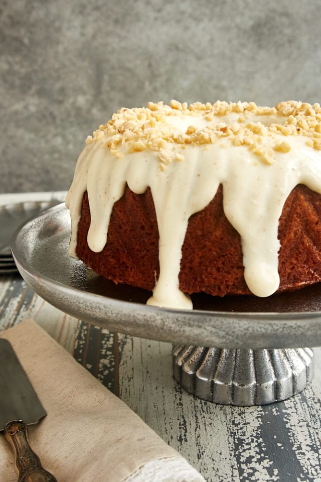 Cinnamon Hazelnut Bundt Cake topped with a brown butter glaze and displayed on a pewter cake stand