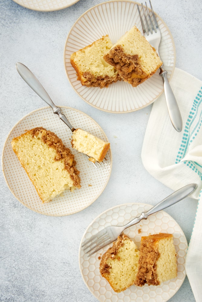 overhead view of slices of Sour Cream Coffee Cake on white and beige plates