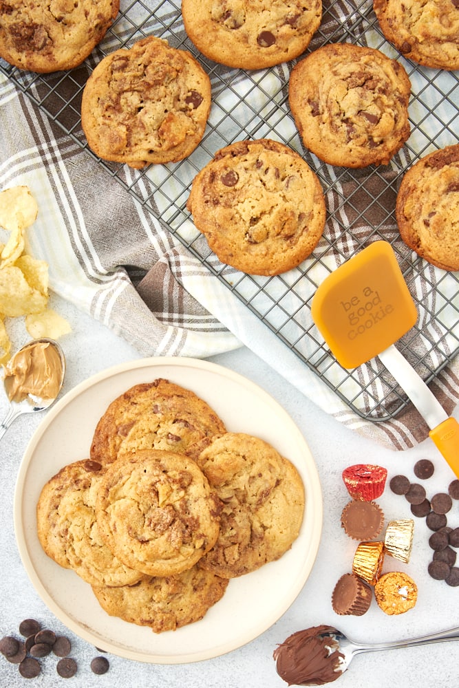 Loaded Nutella Peanut Butter Cookies piled on a beige plate with more on a wire cooling rack