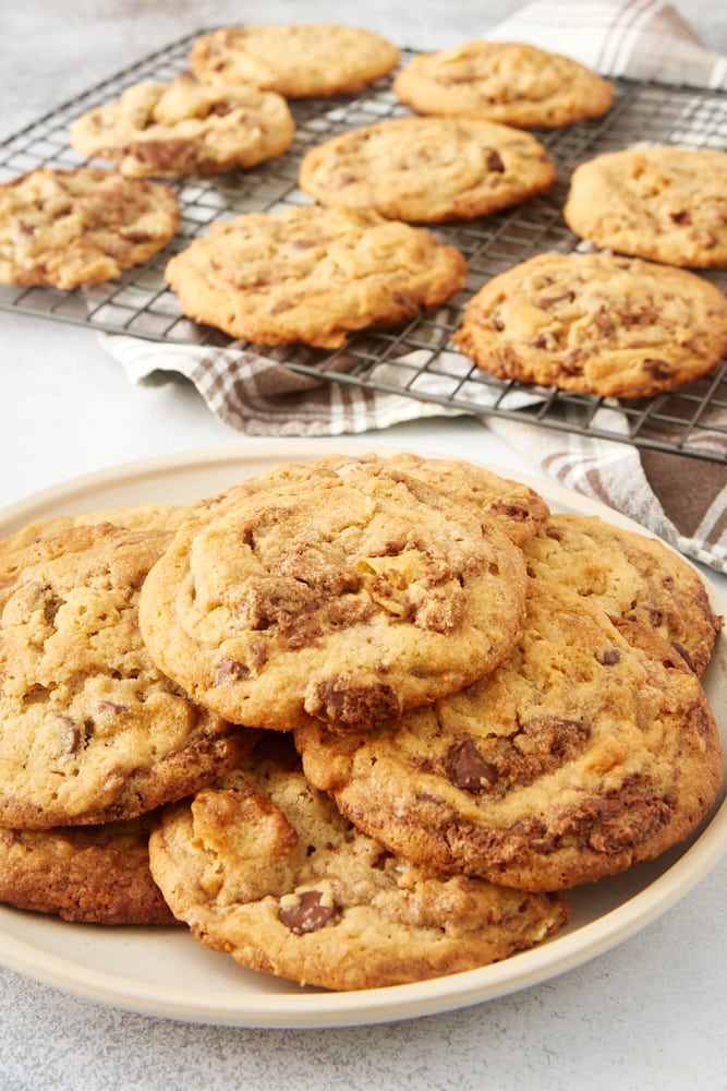 Nutella Peanut Butter Cookies on a beige plate with more cookies on a wire rack in the background