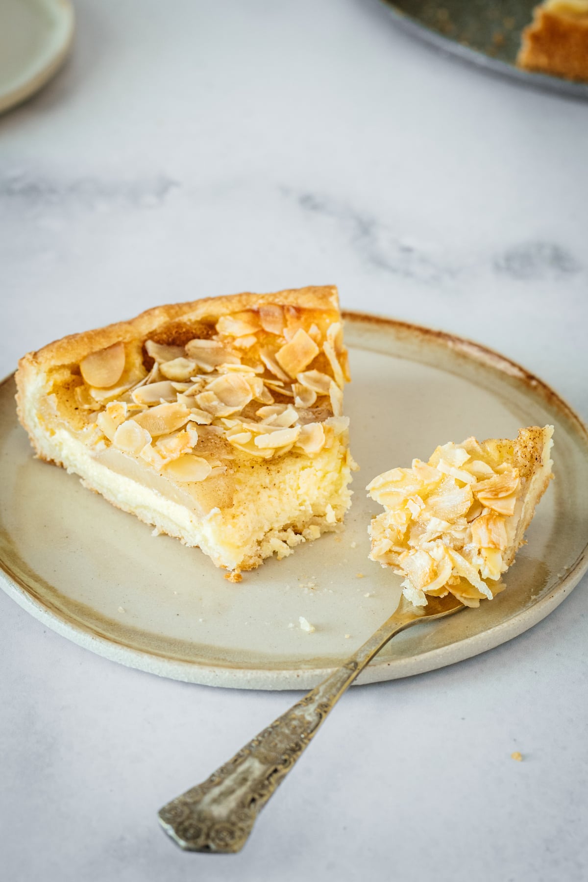 Almond Pear Cream Cheese Tart on plate with bite of tart on fork