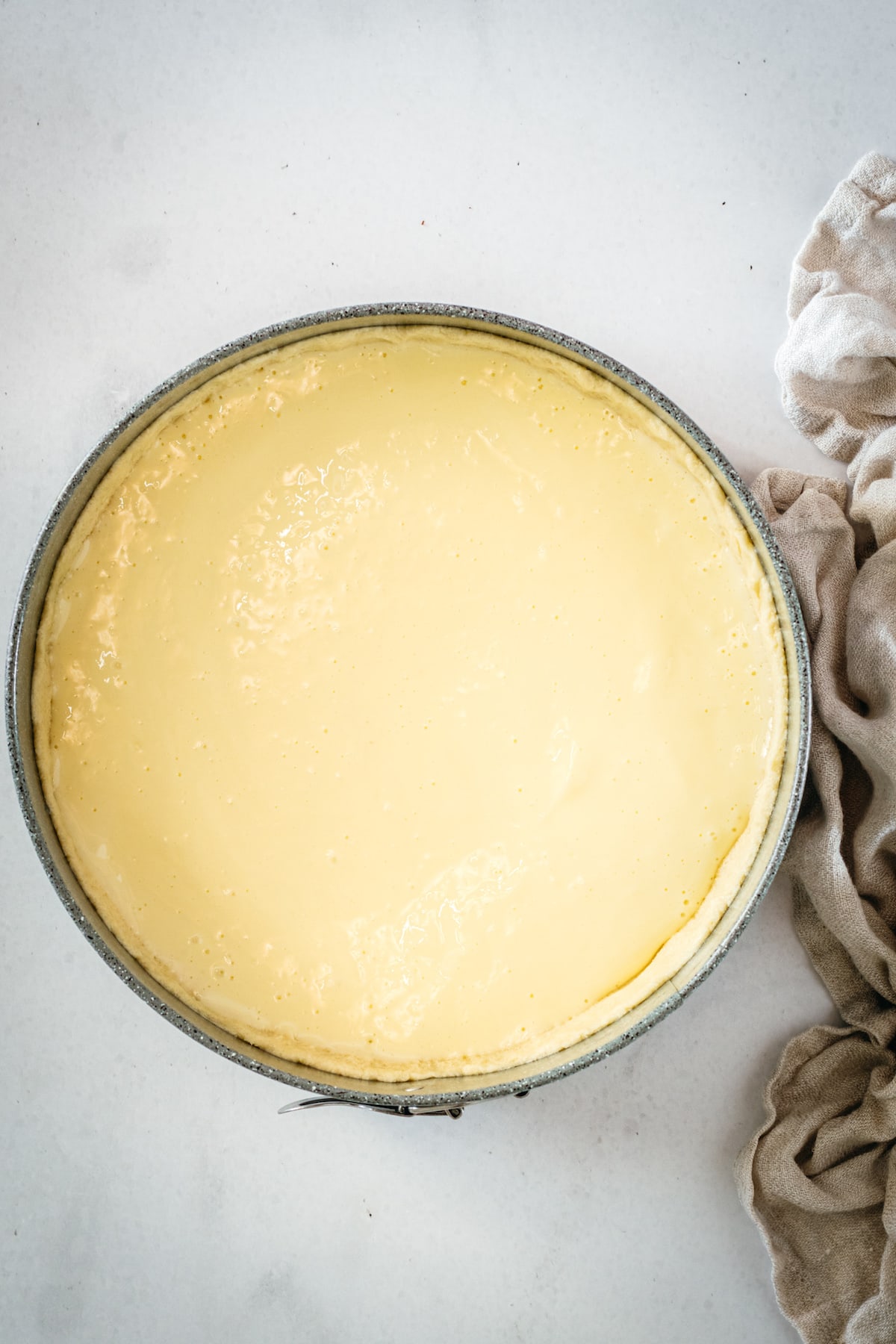 Overhead shot of cream cheese layer of pear tart in springform pan