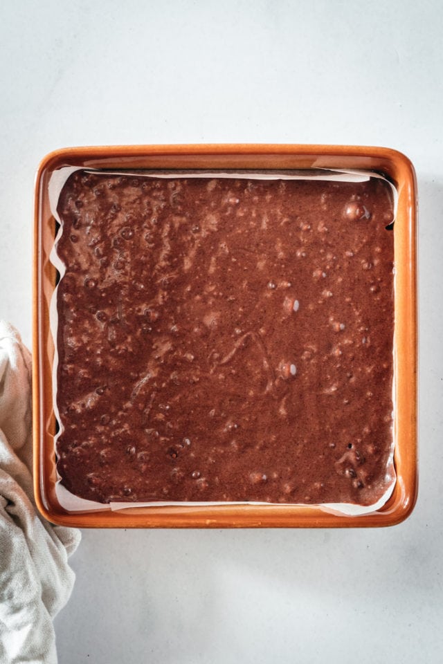 Overhead view of brownie batter in square pan