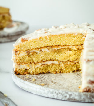 Italian Cream Cake on cake plate with two slices removed, showing layers