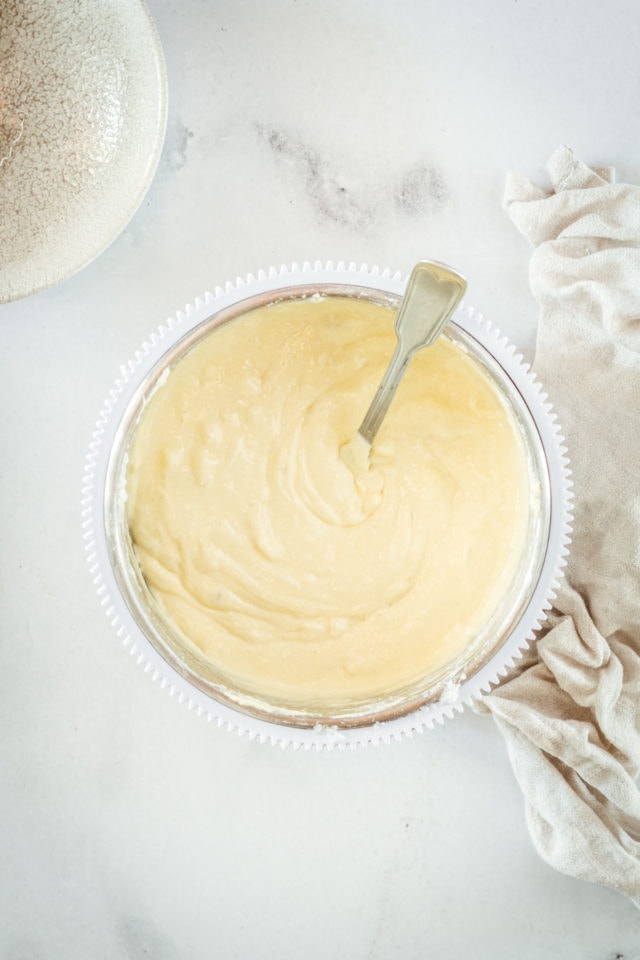 Overhead shot of cake batter in glass mixing bowl with spoon