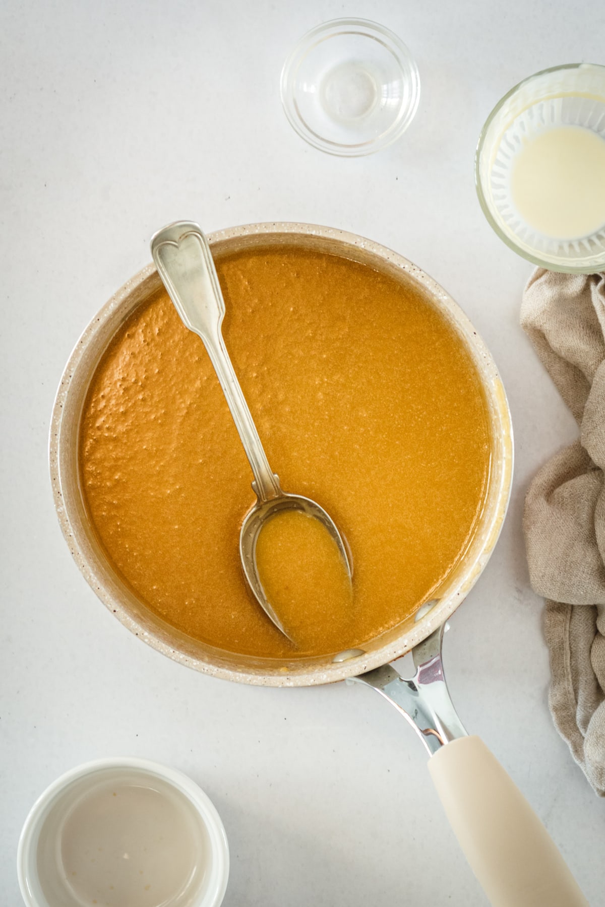 Overhead view of butterscotch in saucepan with spoon