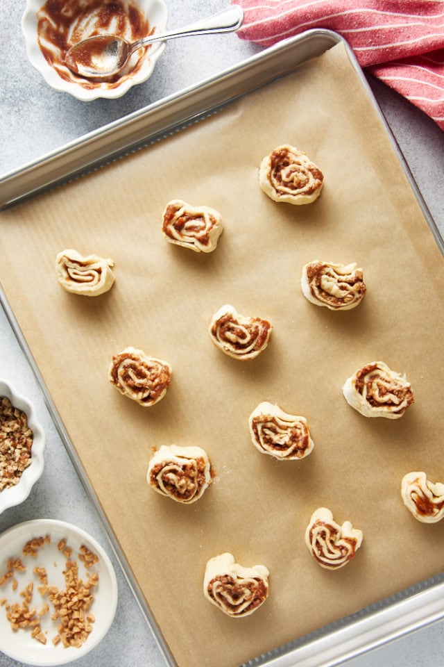 overhead view of Apple Butter Pinwheels on a parchment-lined baking sheet ready for the oven