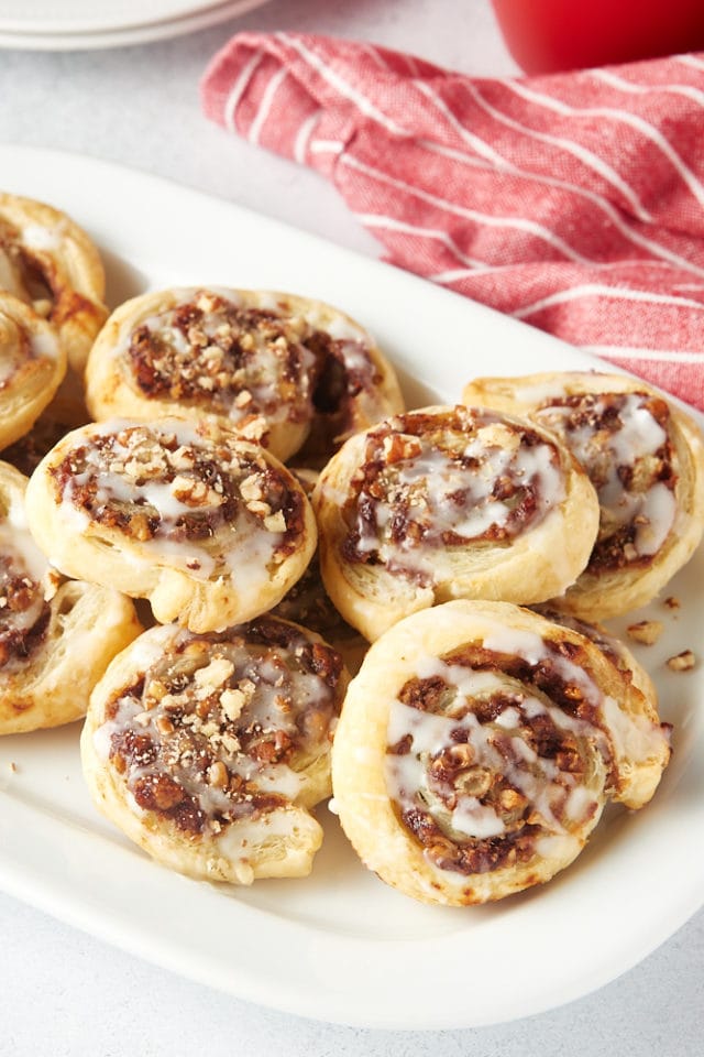 apple butter-filled puff pastry swirls piled on a white tray