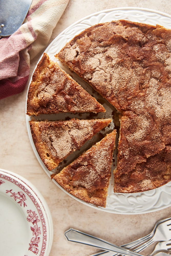 overhead view of Cinnamon Pear Cake partially sliced on a white cake plate