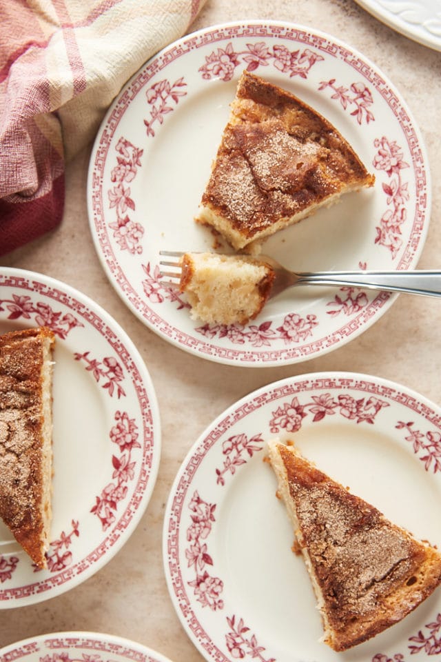 slices of Cinnamon Pear Cake on red floral-rimmed white plates