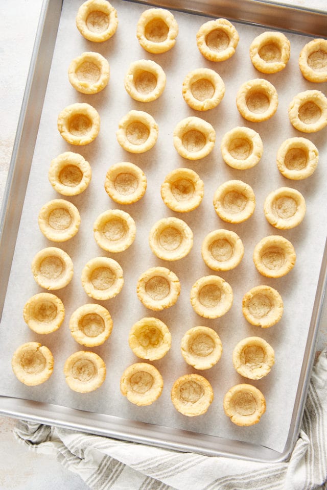 baked cream cheese pie crusts on a baking sheet lined with parchment paper