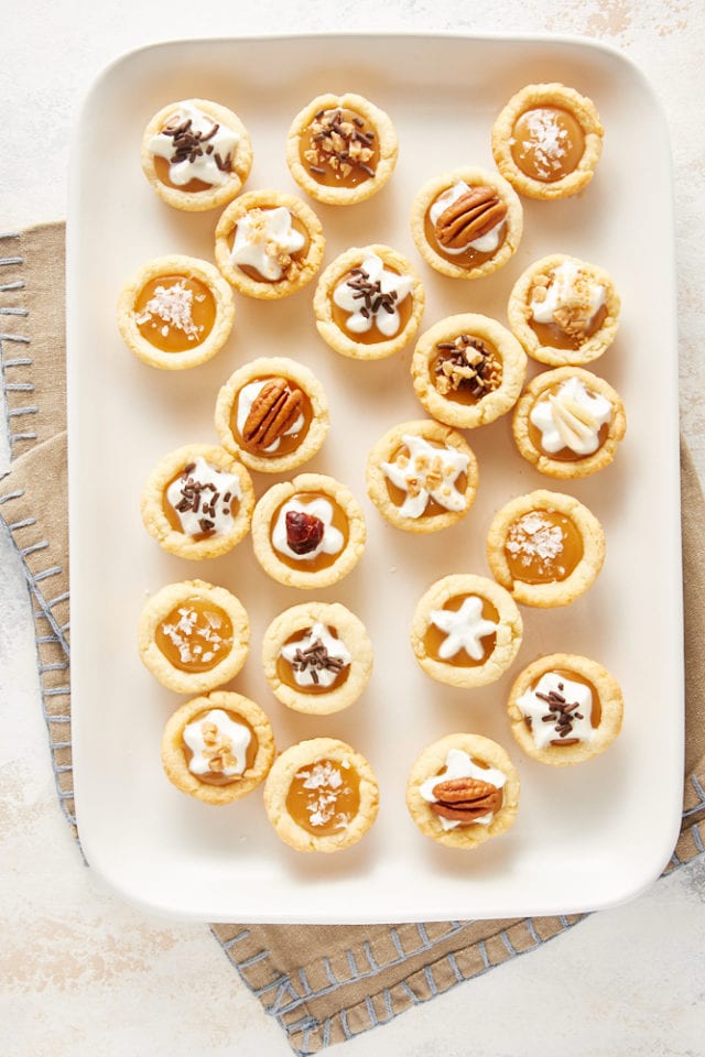 overhead view of Mini Caramel Tarts on a white serving tray