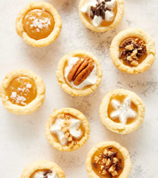 overhead view of Mini Caramel Tarts on a white and gray surface