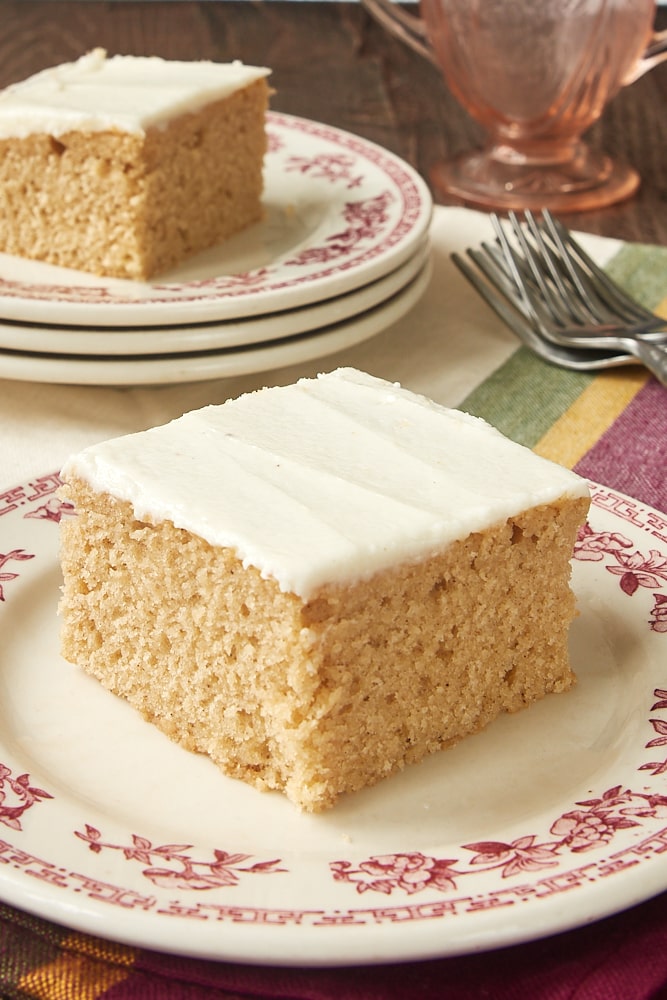 Square of spice cake on plate, with another slice on plate in background