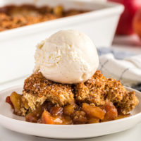 serving of Brown Sugar Apple Cobbler topped with ice cream and served on a white plate