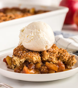 serving of Brown Sugar Apple Cobbler topped with ice cream and served on a white plate