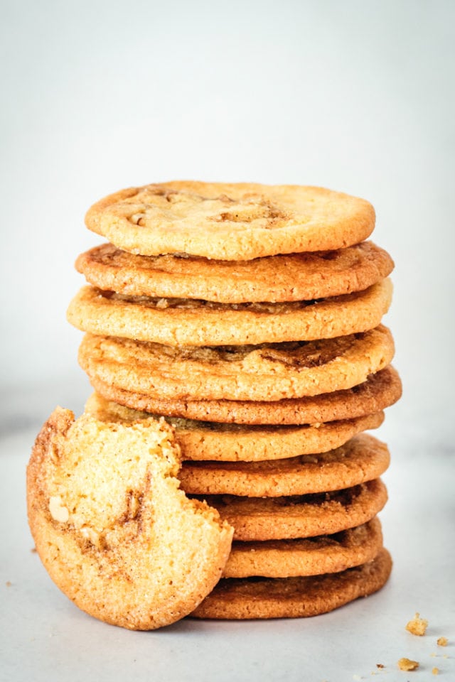 Stack of Cinnamon Roll Cookies with one leaning against them with two bites taken out