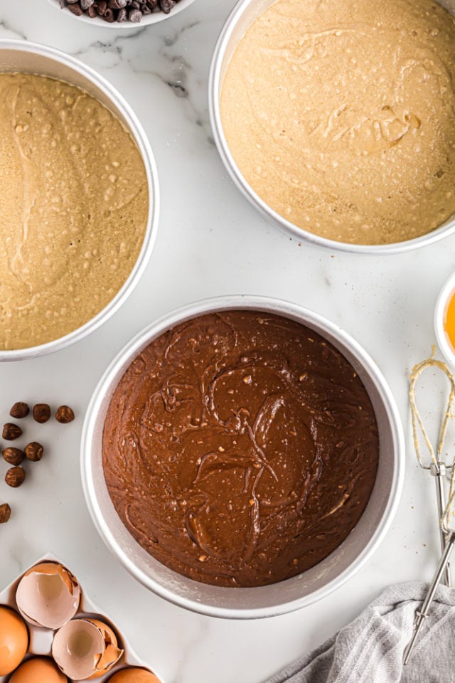 overhead view of Double Nut Chocolate Cake batter in three round cake pans