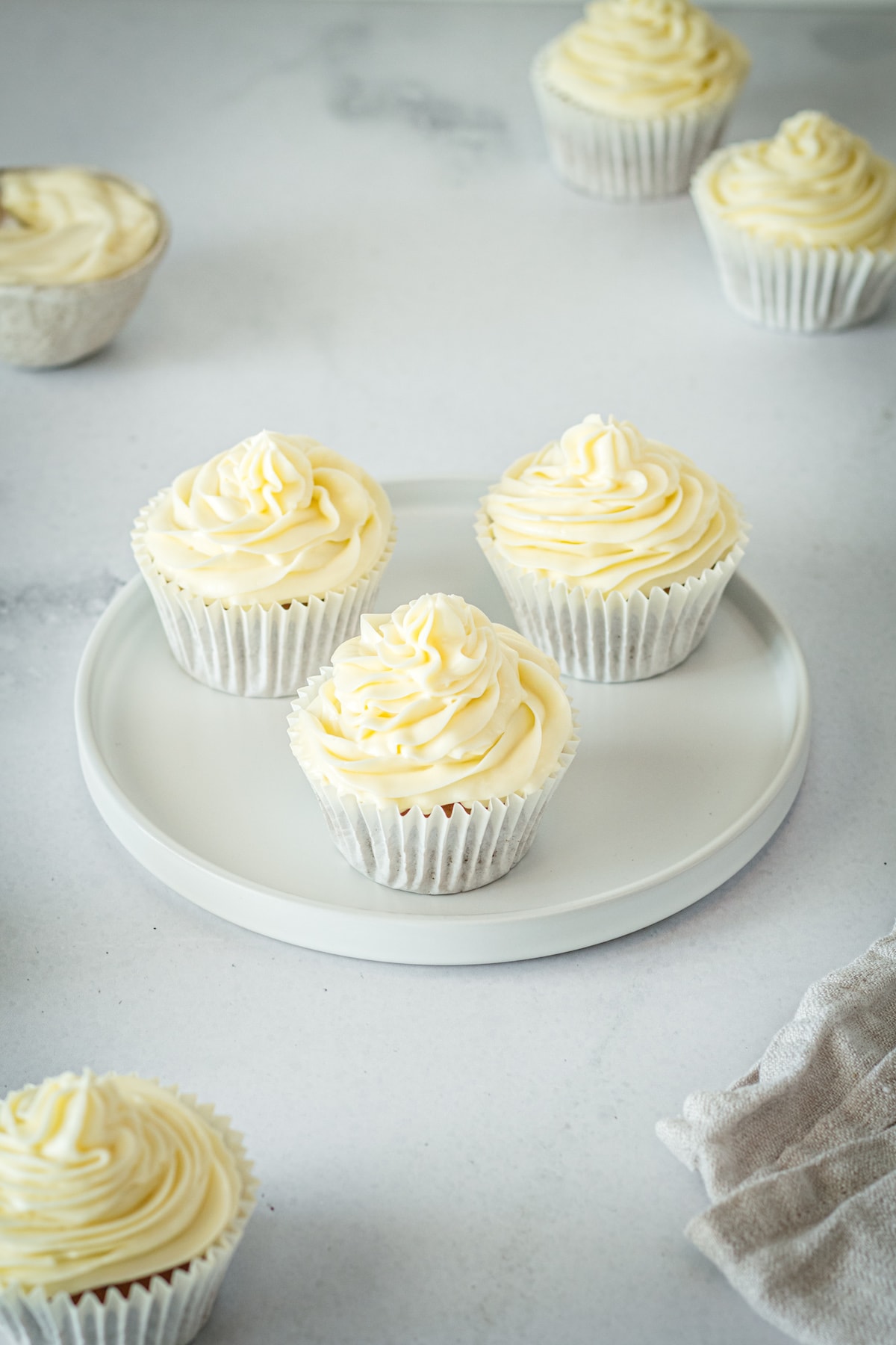 Three gingerbread cupcakes in wrappers on white plate