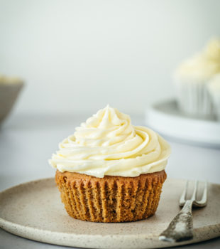 Unwrapping gingerbread cupcake on plate with fork
