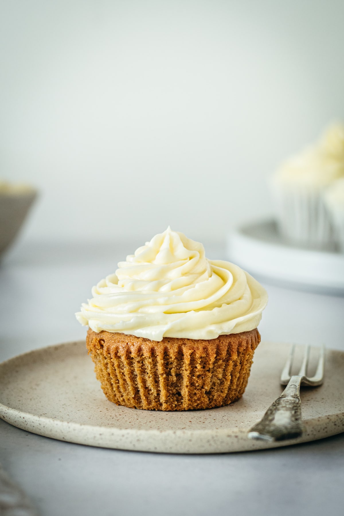 Unwrapping gingerbread cupcake on plate with fork