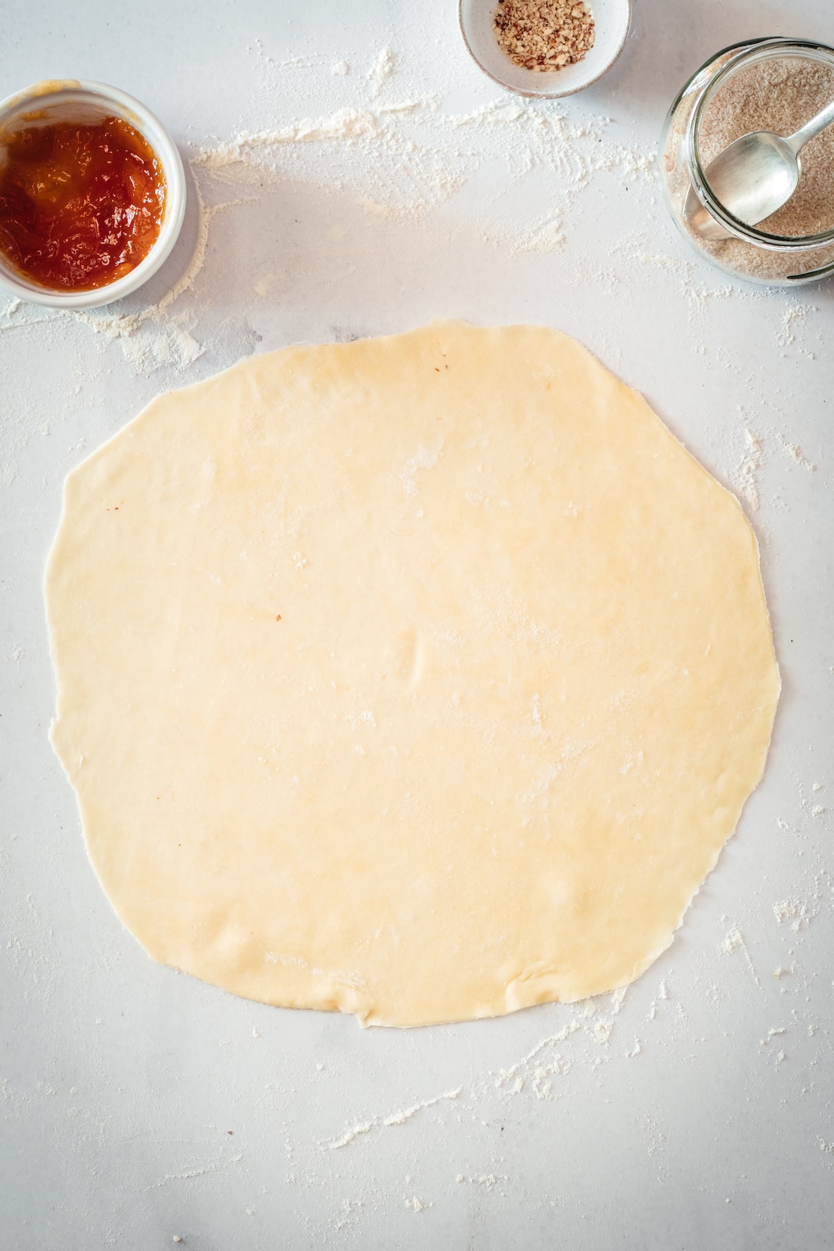 Circle of dough rolled out on marble surface