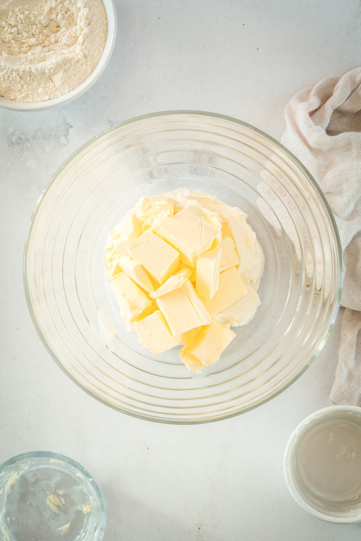 Overhead view of butter and cream cheese in glass mixing bowl
