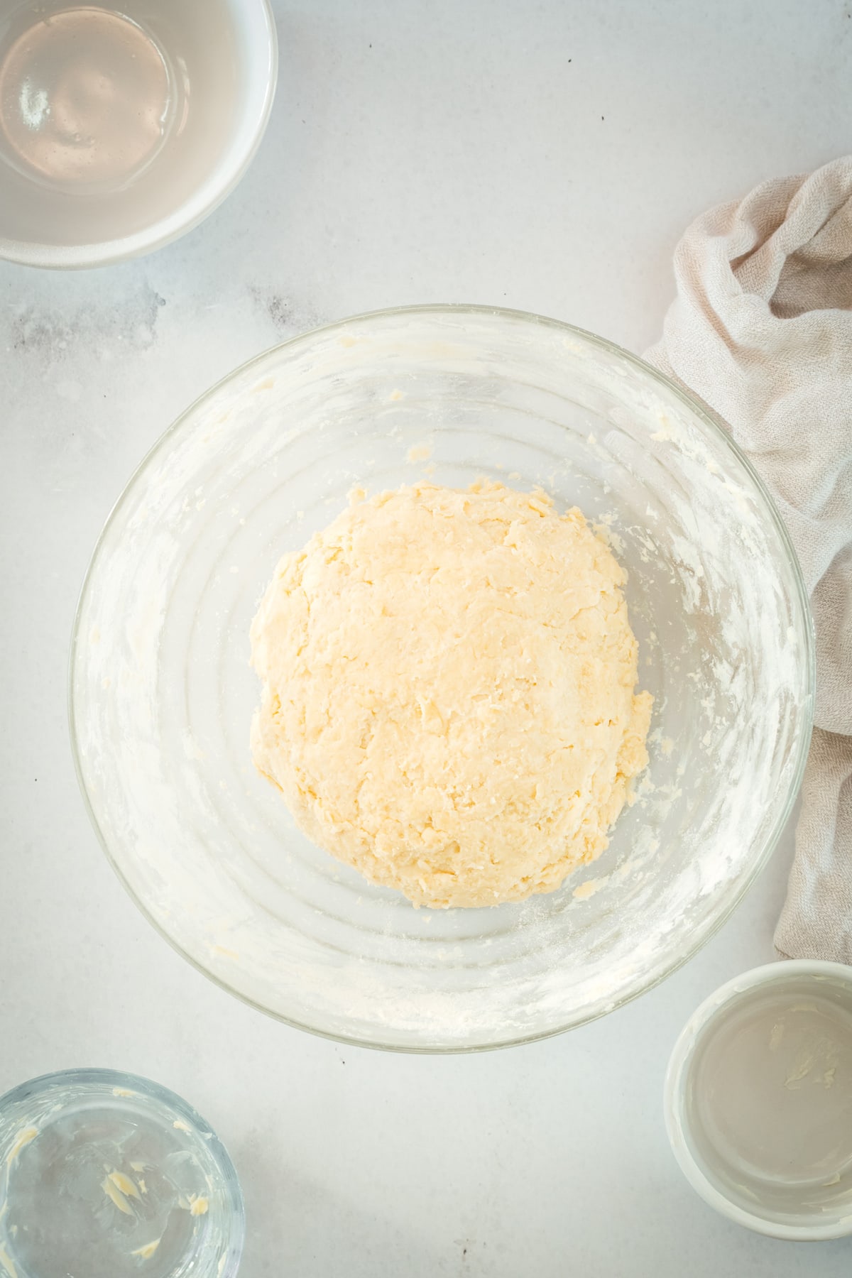 Overhead view of dough in glass mixing bowl