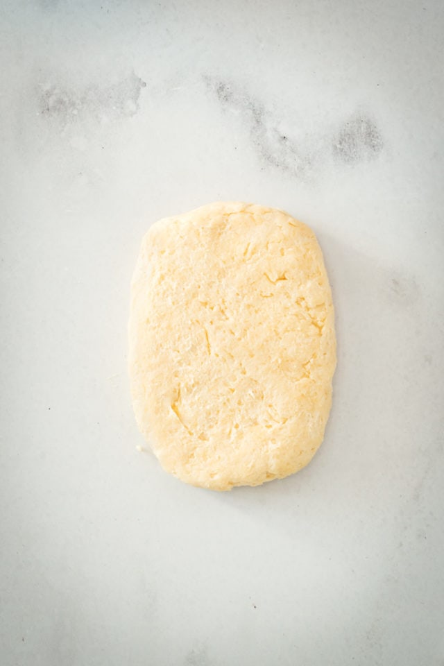 Overhead view of rectangle of dough on marble slab