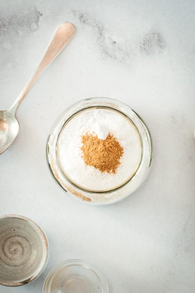 Overhead view of sugar and cinnamon in jar with spoon