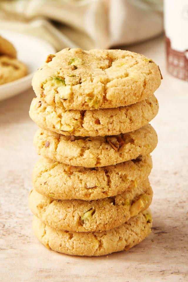 stack of Brown Butter Pistachio Cookies on a beige surface