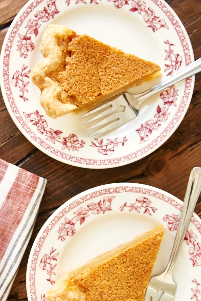 overhead view of two slices of Brown Butter Chess Pie on red floral-rimmed white plates