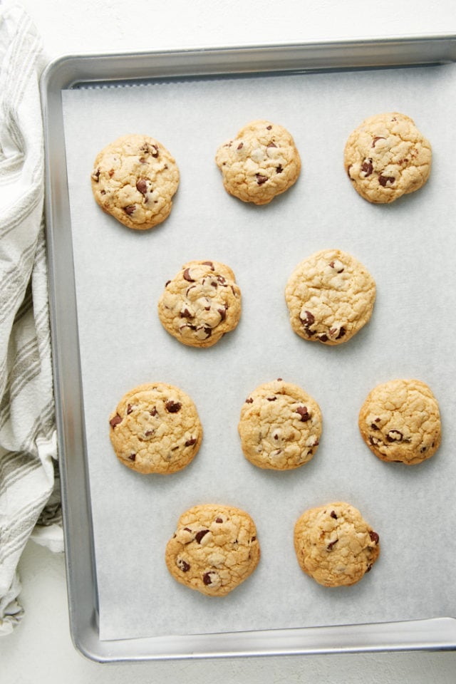 overhead view of freshly baked Chewy Chocolate Chip Cookies on a parchment-lined baking sheet