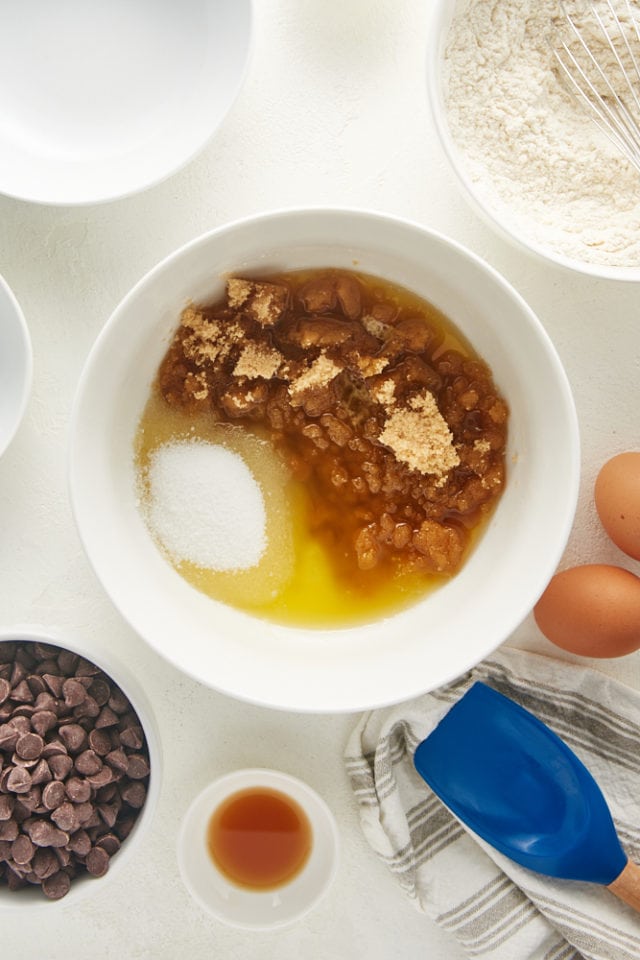 overhead view of melted butter, brown sugar, and sugar in a white mixing bowl