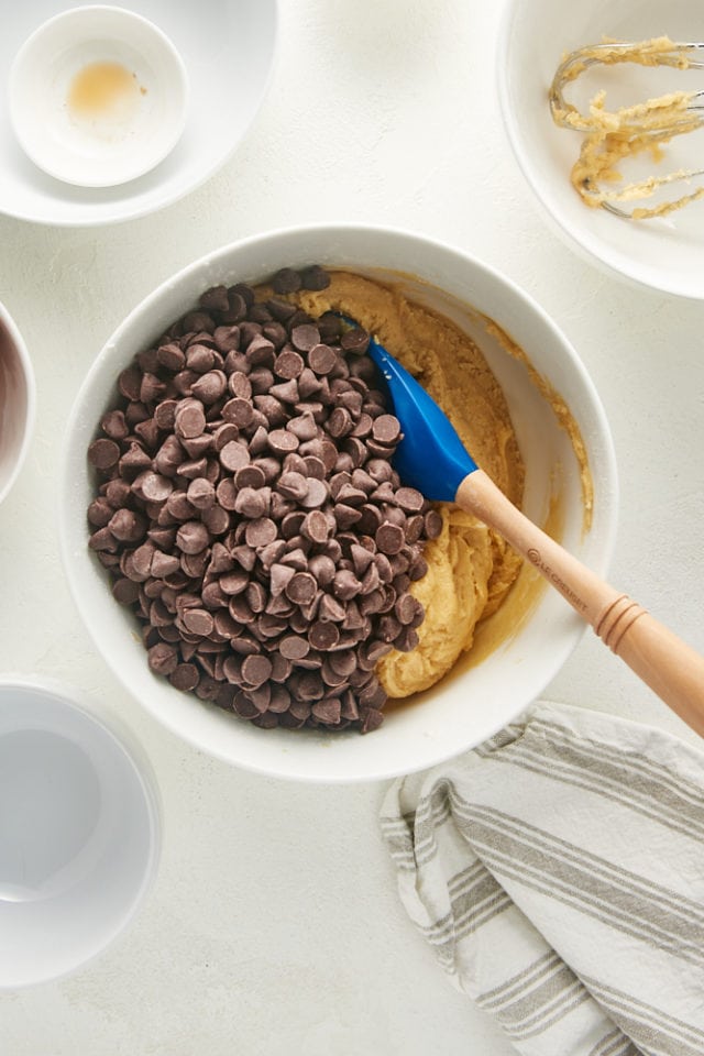 overhead view of chocolate chips added to cookie dough