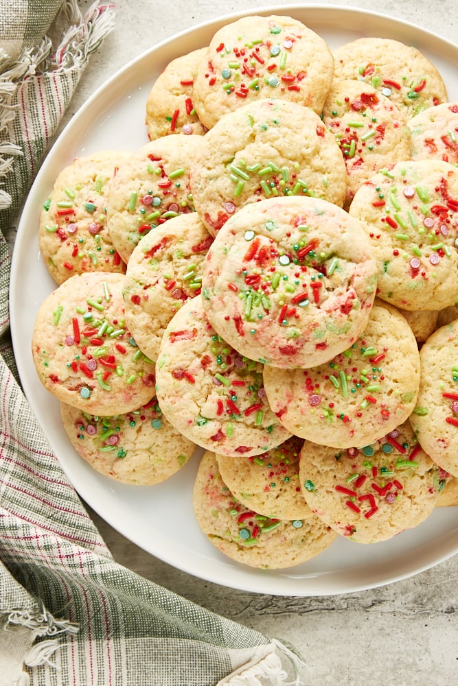 Overhead view of soft Christmas sugar cookies on a large white plate.