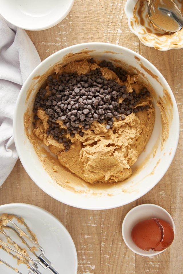 Overhead view of mini chocolate chips added to cookie dough.