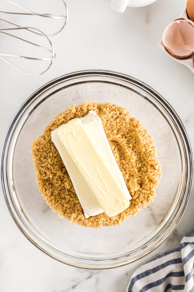 overhead view of butter, cream cheese, and brown sugar in a glass mixing bowl