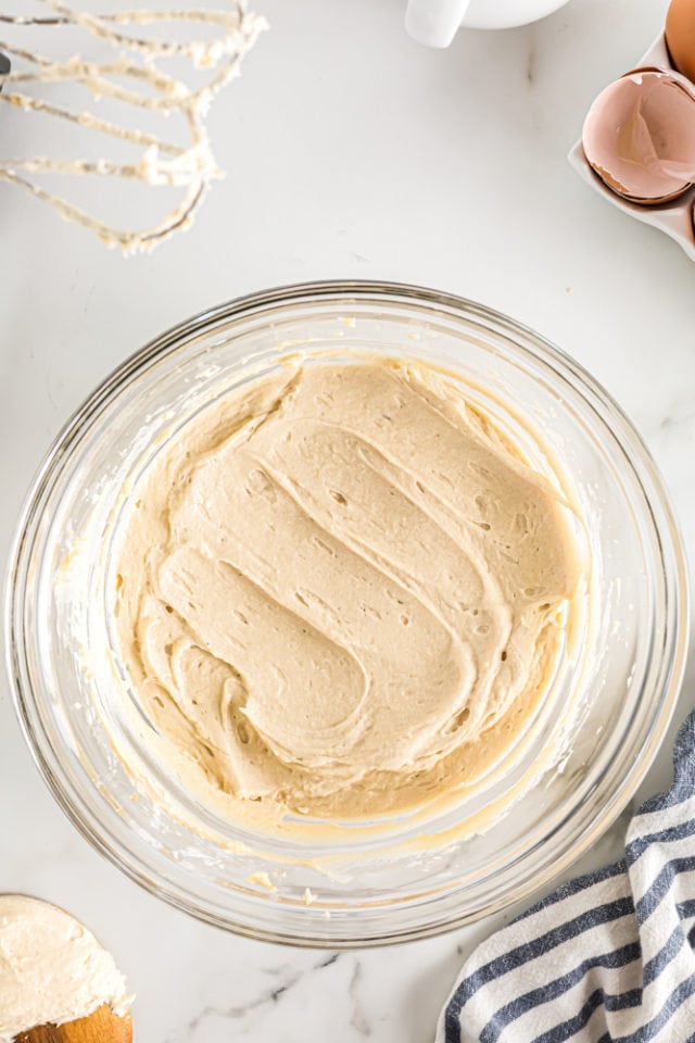 overhead view of mixed brown sugar cream cheese frosting in a glass mixing bowl